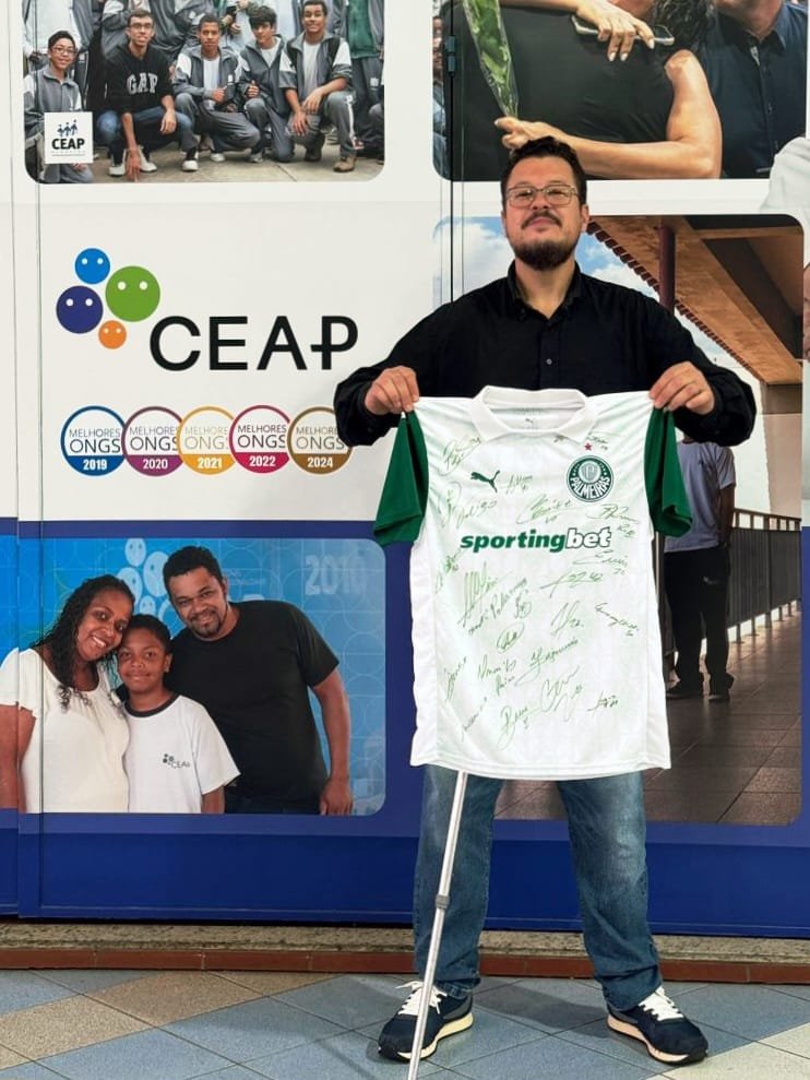 Professor Marcelo Nunes segurando a camisa oficial do Palmeiras autografada, que será sorteada nesta ação